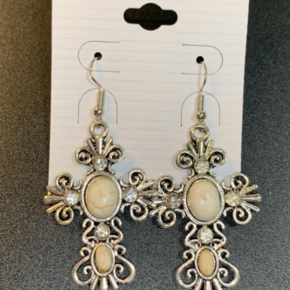 Silver tone cross earrings with ornate scrollwork and oval cream colored howlite